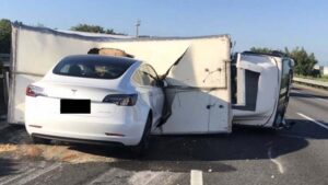 Mobil Tesla Tabrak Truk Terguling