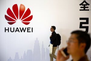 Pria Berlalu Lalang di depan Papan Iklan Huawei di Beijing, Tiongkok (China) Lisensi Usaha di AS